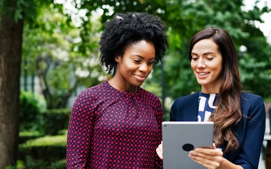two women watching a tablet
