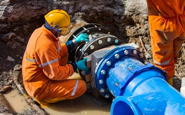 Industrial plumber installing water pipes