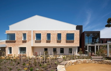 Hospital building facade with brick walls and landscaped garden
