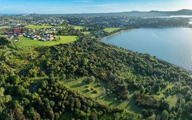 Aerial view of a coastal rural community with homes, green fields, and waterways, illustrating flood risk and resilience planning.