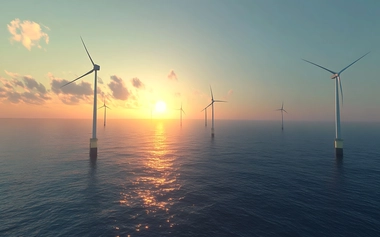 Offshore wind turbines in the ocean at sunset.