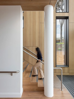 Staircase with wood panels and person moving down steps