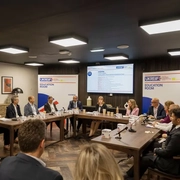 Speakers gathering around a table during the UKREiiF Event