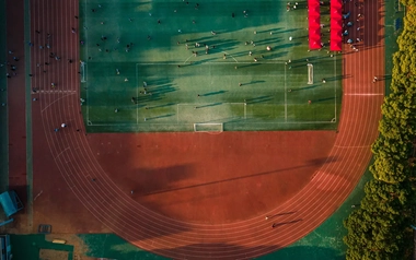 AdobeStock_636426681_Aerial-view-of-a-large-running-track-surrounded-with-lush-greenery