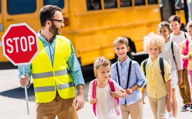 Crossing guard helping kids cross the street