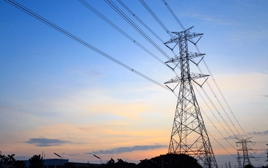 Electric grid against blue and orange sky.