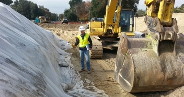 Field professional oversees environmental remediation activities alongside heavy equipment