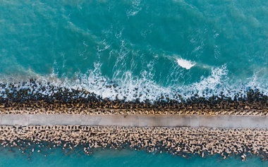 AdobeStock_479276316_Aerial_photo_of_a_breakwater_facing_the_sea