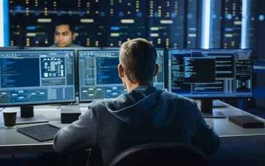 IT personnel working with coding on a computer