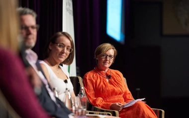 Panel discussion with speakers seated on stage at an industry event.