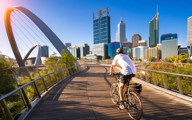 Cyclist on a bridge with city skyline