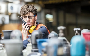  GettyImages_1296856257_Male Worker working in a gas cylinders distribution warehouse while talking on walkies talkie.