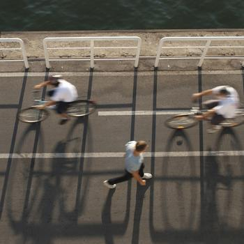 a cyclist and a man walking