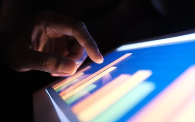 person touching a monitor to check digital data